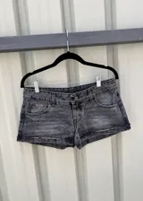 Short de jean de tiro bajo, color negro gastado, de corte ajustado y botamangas con dobladillo deshilachado.