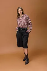 Camisa de corte relajado con estampado de cuadros en tonos bordó, blanco y negro. Presenta cuello camisero, cierre frontal con botones y mangas largas con puños abotonados.