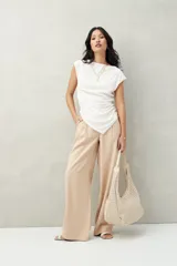 Pantalón sastrero ancho color crema con finas rayas verticales, de cintura alta con pinzas.