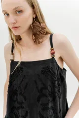 Vestido corto color marrón, con breteles finos, escote recto y bordado floral en el frente.