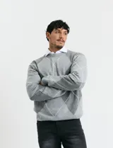 Sweater de punto con diseño de rombos en gris y azul marino, escote redondo a la base, manga larga y terminaciones en punto acanalado en cuello, puños y ruedo.