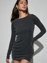 Vestido corto negro con brillo, de manga larga, cuello redondo y ajuste al cuerpo.