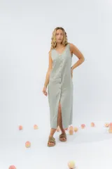 Vestido largo de lino con escote en V, diseño recto y fluido, con cierre frontal abotonado mediante botones de madera.