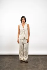 Chaleco de lino con escote en V y cierre frontal de botones, de corte sastrero y diseño entallado.