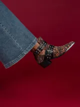 Botín de gamuza con estampado de leopardo, punta fina y apliques de correas de cuero sintético negro con hebillas metálicas.