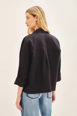 Saco corto de lino con corte oversize y mangas amplias. Presenta un diseño de doble abotonadura frontal y forro interior de lino.