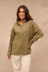 Camisa verde oliva de manga larga, corte oversize, con cuello camisero, cierre frontal de botones y un bolsillo aplicado en el pecho.