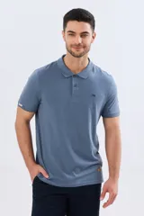 Remera polo de manga corta en color azul melange, con cuello camisero, cierre frontal de dos botones y pequeño bordado en el pecho.
