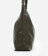 Cartera hobo grande de poliuretano color verde militar, con diseño slouchy, base estructurada y una única asa larga para llevar al hombro. Cuenta con cierre de botón a presión y amplio compartimento interior.