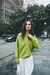 Sweater de punto color marrón, con cuello redondo y cierre frontal parcial con botones. Manga larga y diseño clásico.