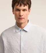 Camisa celeste de viscosa y poliéster con textura arrugada, cuello tradicional, manga larga y abotonadura frontal completa.