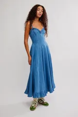 Vestido midi de denim azul, con silueta en línea A, escote corazón, tirantes finos y detalle de volados en el ruedo.