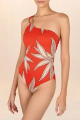 Traje de baño entero asimétrico color naranja con estampado de hojas beige y detalle de hebilla de madera en el tirante.