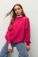 Polera de punto color naranja con mangas abullonadas, puños elastizados y cuello alto a la base.