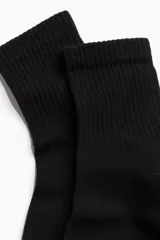 Pack de tres pares de medias negras de punto fino con caña acanalada y elástico superior.