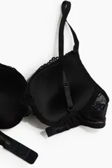 Soutien push-up negro de encaje con aros y copas acolchadas, breteles ajustables y cierre de corchetes en la espalda.
