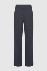 Pantalón de vestir color marrón con silueta amplia, corte recto y caída fluida. Presenta costuras verticales frontales que estilizan la figura y cierre clásico.
