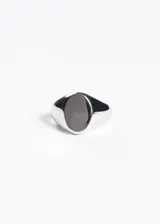 Anillo sello plateado de acero quirúrgico con forma ovalada lisa.