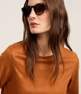 Blusa de manga corta y cuello redondo, confeccionada en tejido sintético de gamuza en color tostado.