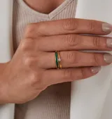 Anillo de oro 18k con diseño de alianza fina y un brillante engastado, presentado en conjunto con otros anillos de oro de diseño entrelazado.