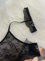 Conjunto de lencería de tres piezas en encaje negro. Incluye bralette con breteles regulables, collarín integrado con cuello ajustable y tanga regulable con corte media less.