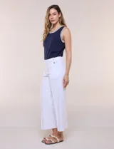Pantalón crop blanco de corte recto con cintura ancha y botones decorativos laterales. Cuenta con bolsillos y pinzas frontales.