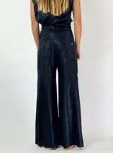 Pantalón blanco de corte palazzo, tiro alto y cintura elástica. Confeccionado en tela ligera con textura.