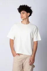 Remera de corte boxy y holgado, confeccionada en algodón pesado, con cuello redondo y diseño liso.