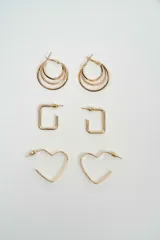 Set de tres pares de aros dorados con diferentes diseños: aros tipo argolla triple, aros rectangulares y aros con forma de corazón.