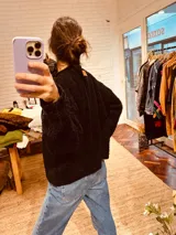 Sweater negro tejido en boucle, de corte holgado y cuello redondo.