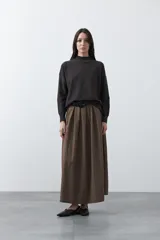 Polera de tejido de punto color gris oscuro, con cuello alto y diseño de rombos en relieve en el frente. Presenta un calce relajado con terminaciones en rib en cuello, puños y ruedo.