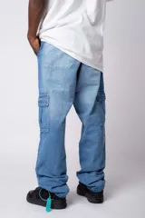 Pantalón cargo de jean con lavado ácido en tono gris, corte holgado, bolsillos laterales tipo cargo y bolsillos frontales tipo parche.