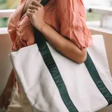 Bolso tipo tote de lona color rojo con asas de cinta negra con la marca Terrano estampada en blanco.