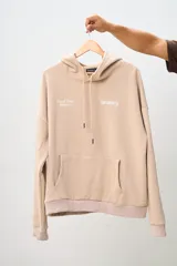 Canguro color beige con capucha, bolsillo tipo canguro y puños y cintura acanalados. Estampado frontal con el logo de la marca Brokers Wear y la frase "Good Time Makers".