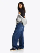 Zapatillas Tommy Jeans de corte bajo, color negro, con exterior de ante, interior de poliéster y suela de goma color caramelo. Presentan un panel a contraste en el talón, logo de Tommy Jeans en la lengüeta y etiqueta de la marca en el lateral.