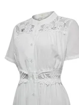 Vestido midi de lino y viscosa color blanco, con cuello mao, mangas cortas y cierre frontal con botones. Presenta detalles de encaje en la parte superior y en la cintura, con forro interior a tono.