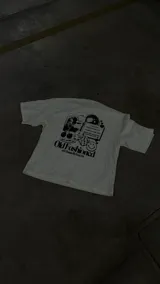 Remera blanca de algodón con estampado negro que incluye la receta del cóctel Old Fashioned, dados, cerezas y una carita sonriente.