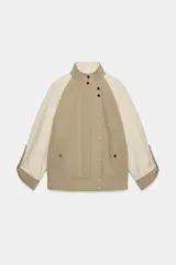 Cazadora acolchada de diseño bicolor en tonos beige y tostado, con cuello subido, manga larga con trabillas, bolsillos delanteros con botón a presión y cierre frontal de botones a presión.