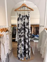 Vestido largo de modal con estampado floral en tonos blanco y negro, de silueta amplia y caída fluida, escote fruncido y tiras finas para atar al cuello. Cuenta con forro corto interno y tajo en la espalda.