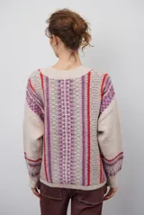 Cardigan de punto con escote en V y cierre frontal de botones. Presenta un diseño estampado con patrones geométricos en tonos beige, marrón y detalles en azul vibrante.