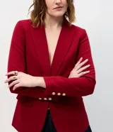 Blazer de sastrería en crepé color negro, con cuello solapa, cierre frontal de un solo botón dorado y bolsillos laterales con solapa.