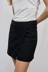 Short cruzado de tiro medio con diseño frontal tipo falda, color negro, de líneas simples y calce cómodo.