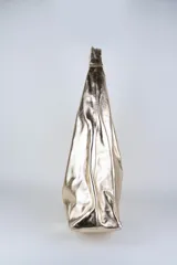 Cartera de cuero vacuno con pelo en diseño animal print similar a piel de ciervo, silueta triangular y asa integrada.