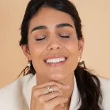 Medio aro de oro 18k con perla de cultivo colgante. Diseño minimalista y elegante.