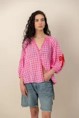 Camisa de manga larga con estampado a cuadros vichy en tonos rosados, escote en V con detalles bordados y diseño holgado.