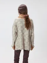 Pullover de punto jacquard color tostado con cuello alto y puños acanalados en tono azul y detalles en naranja. Cuenta con aberturas laterales y calce holgado.