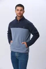 Buzo de polar bicolor azul marino y verde con medio cierre y bolsillos laterales con cierre.