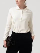 Remera manga larga de piqué de algodón pima color blanco marfil, con cuello camisero, tapeta con botones frontales y sutil bordado en el pecho.