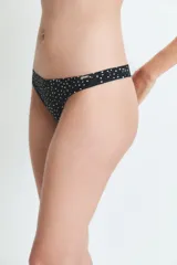 Bombacha tipo colaless de color negro con estampado de lunares blancos, confeccionada en poliamida y elastano con forro de algodón.