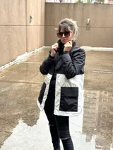 Campera negra con capucha, cierre frontal con cremallera y bolsillos laterales. Interior con forro de animal print.